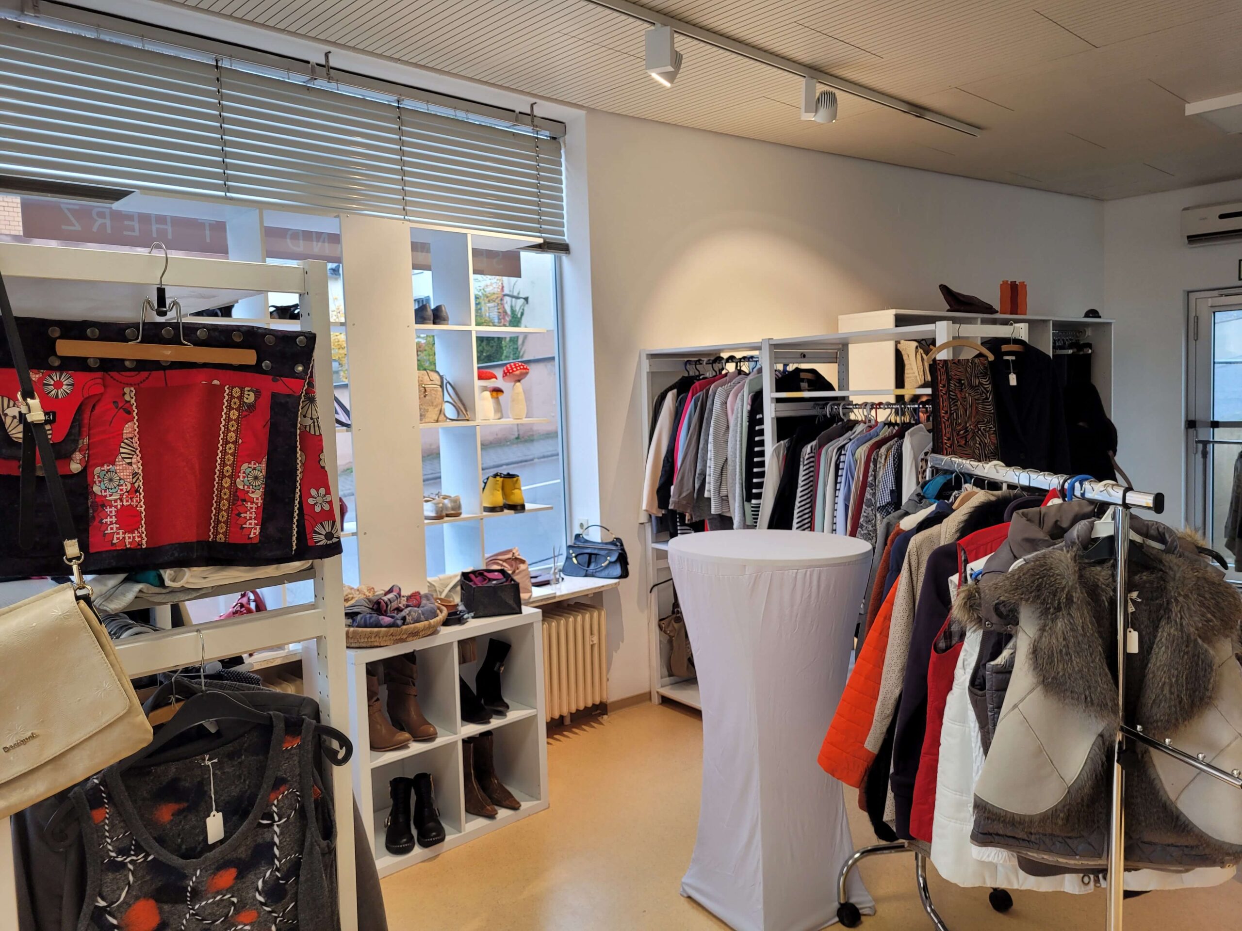 Second-Hand-Laden Innenraum mit Kleidung und Regalen Innenansicht des Second-Hand-Shops mit Kleiderständern und Regalen voller Kleidung
